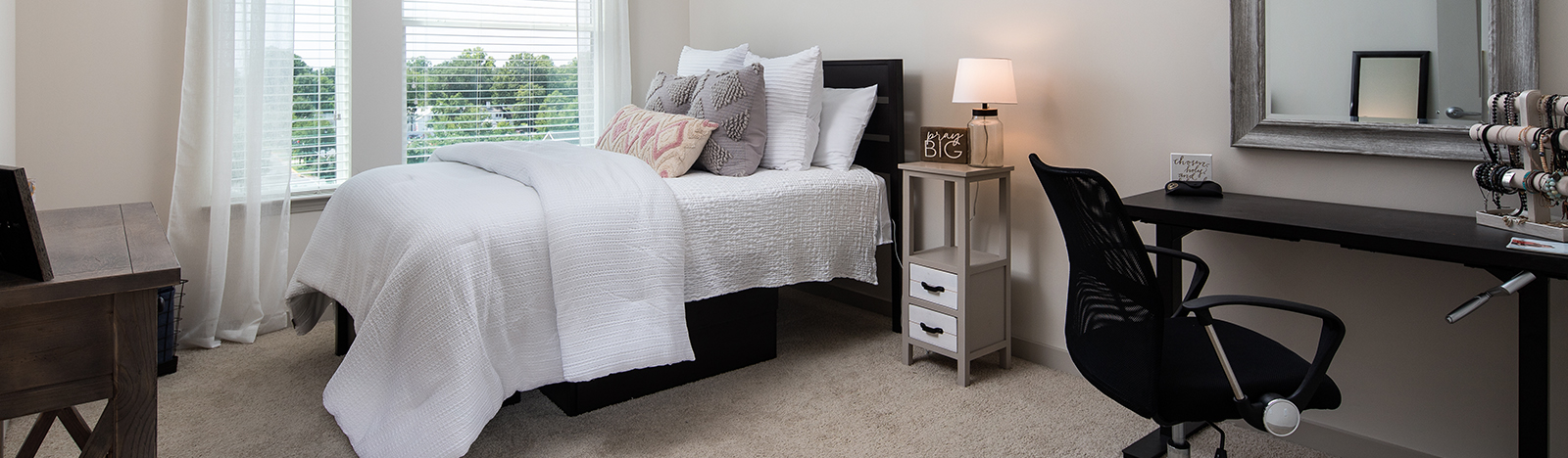 Apartment bedroom furnished with a bed and desk
